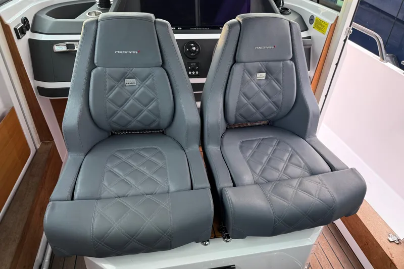 Slide: The Image of Luxury seating in 2021 Axopar 28 Cabin boat, featuring premium gray leather upholstery. - 26