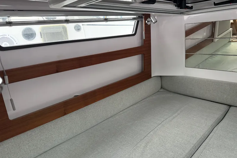 Slide: The Image of Interior of 2021 Axopar 28 Cabin with wooden accents and gray seating. - 29