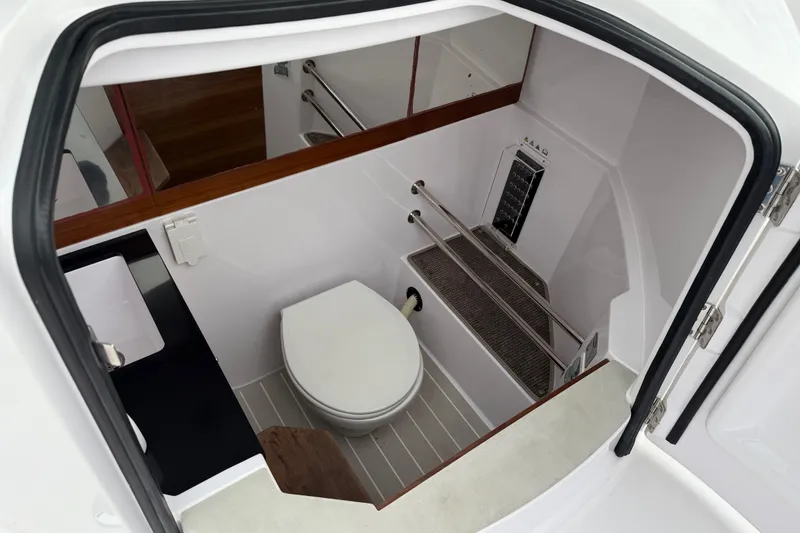 Slide: The Image of 2021 Axopar 28 Cabin interior bathroom with toilet and sink. - 35
