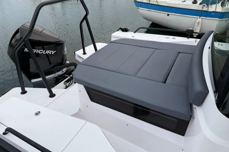 Slide: The Image of 2021 Axopar 28 Cabin boat with Mercury engine and cushioned seating area. - 4