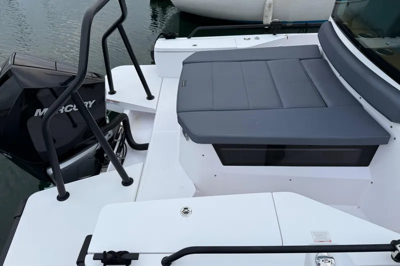 Slide: The Image of 2021 Axopar 28 Cabin boat with Mercury engine, featuring a sleek deck and cushioned seating. - 5