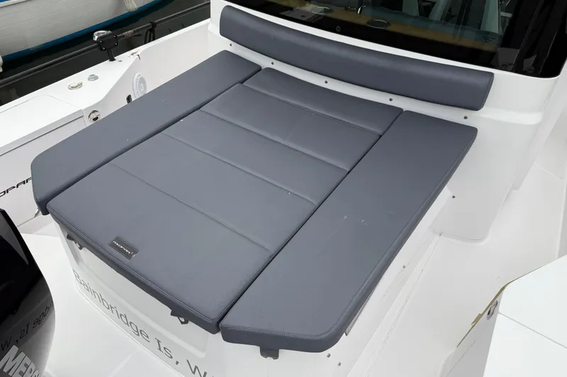 Slide: The Image of 2021 Axopar 28 Cabin boat with cushioned seating area. - 7