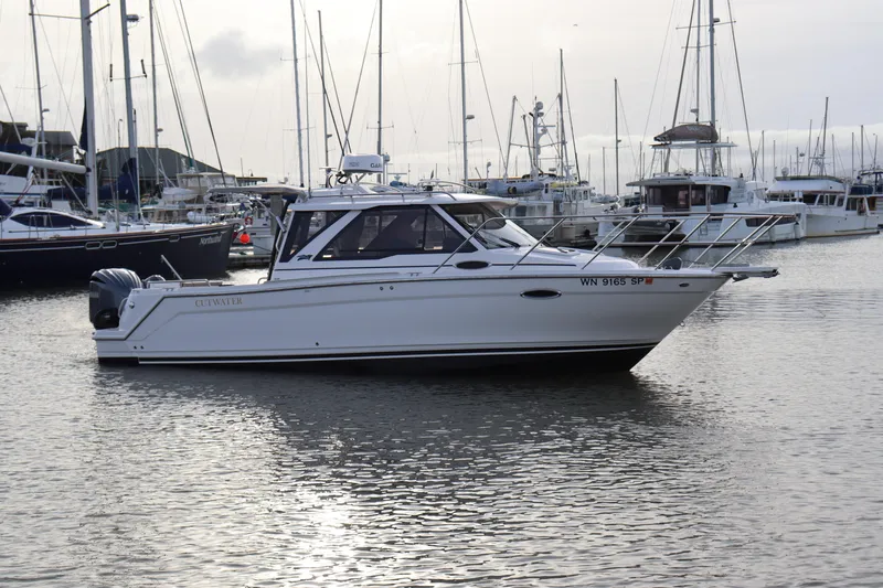 The Image of 2024 Cutwater 248 boat docked in a marina, surrounded by other vessels. - 0