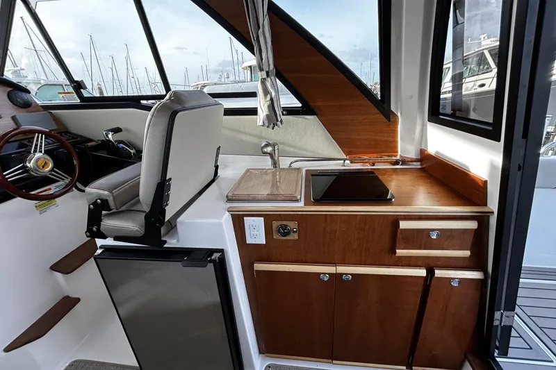 Slide: The Image of 2024 Cutwater 248 boat interior with helm, kitchenette, and modern amenities. - 11