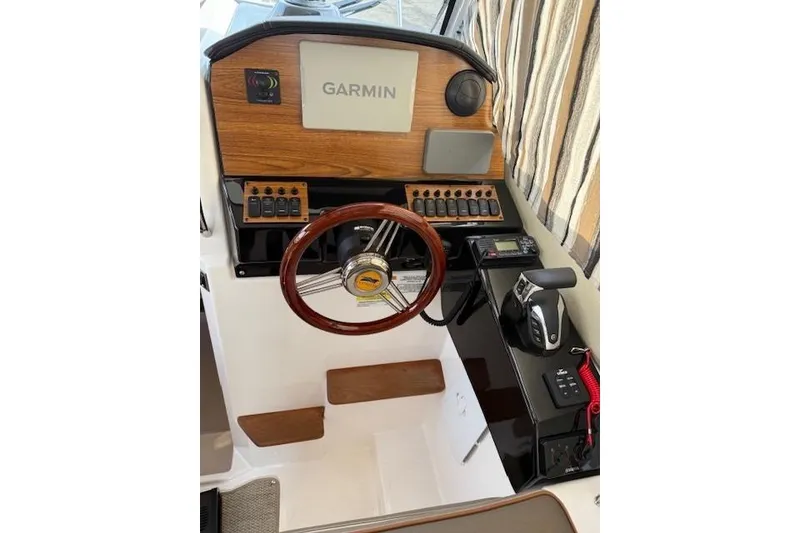 Slide: The Image of 2024 Cutwater 248 helm with Garmin display, wooden accents, and modern controls. - 15
