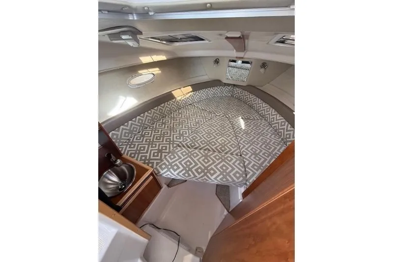 Slide: The Image of 2024 Cutwater 248 boat interior with patterned cushions and compact sink area. - 16