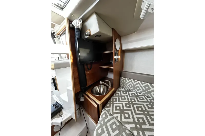 Slide: The Image of 2024 Cutwater 248 interior with TV, sink, and patterned seating. - 18