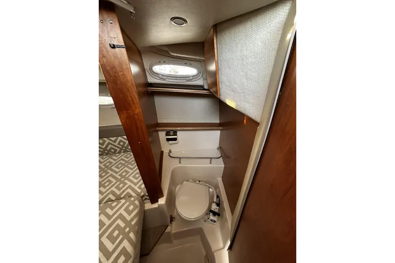Slide: The Image of 2024 Cutwater 248 boat interior with compact bathroom and wooden accents. - 20