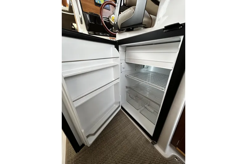 Slide: The Image of 2024 Cutwater 248 boat interior with open refrigerator, showcasing storage space. - 23