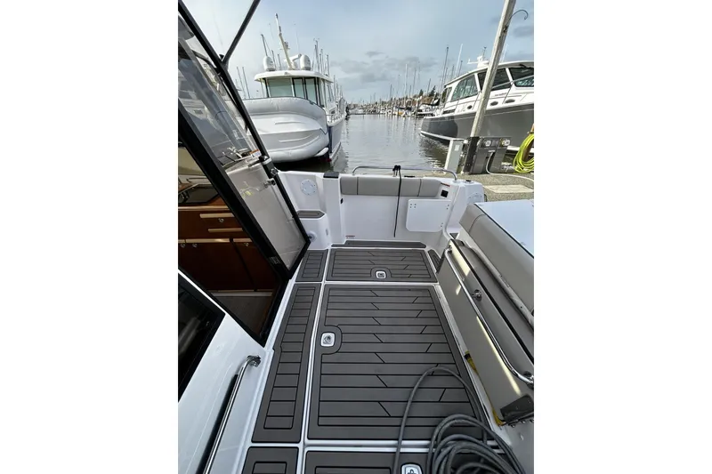 Slide: The Image of 2024 Cutwater 248 boat interior, featuring sleek deck design and marina view. - 6