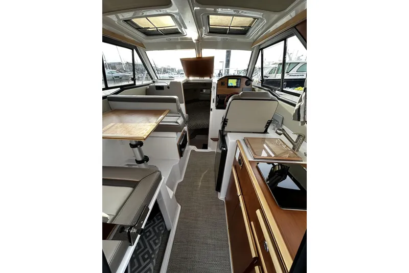 Slide: The Image of 2024 Cutwater 248 boat interior with modern seating, table, and navigation equipment. - 7