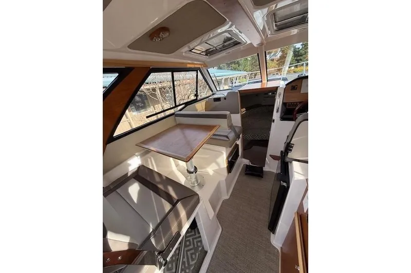 Slide: The Image of 2024 Cutwater 248 boat interior with seating, table, and helm, showcasing modern design. - 8