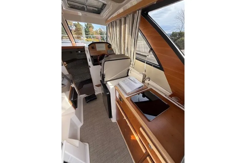 Slide: The Image of 2024 Cutwater 248 boat interior with wood accents, seating, and navigation area. - 9