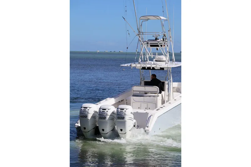 Slide: The Image of 2005 Venture 39 Open boat with triple outboard engines on calm water. - 19