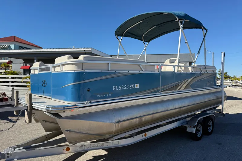 The Image of 2020 Avalon 2280 Venture Quad Lounger pontoon boat on trailer, blue and silver design. - 1