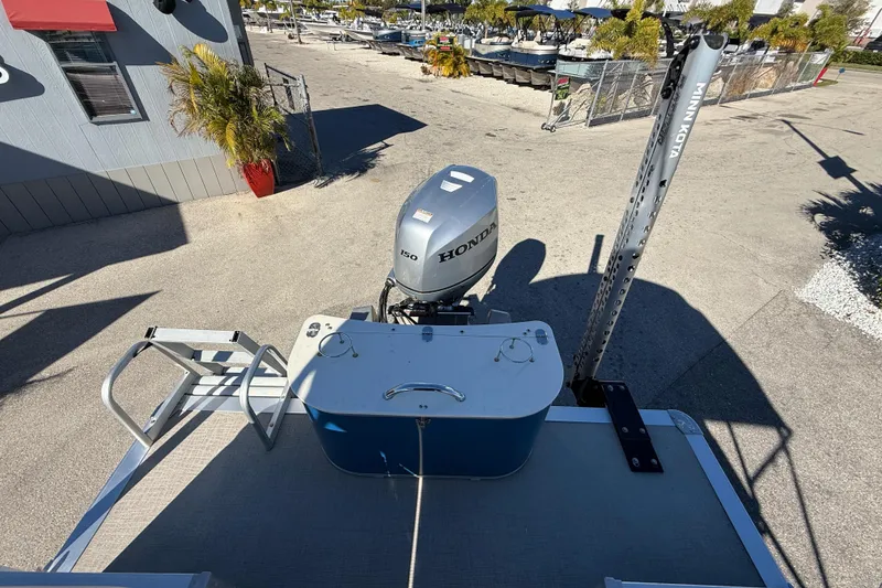 Slide: The Image of 2020 Avalon 2280 Venture Quad Lounger with Honda outboard motor in a sunny marina. - 11