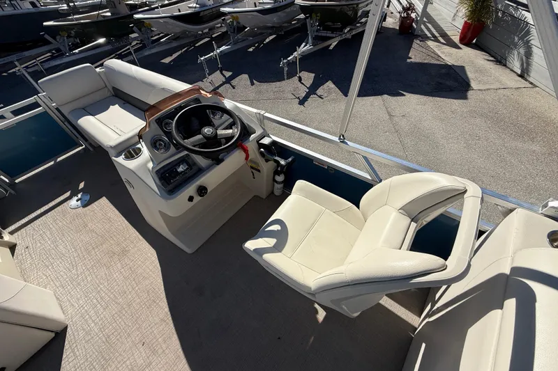 Slide: The Image of 2020 Avalon 2280 Venture Quad Lounger boat interior with steering console and seating. - 17