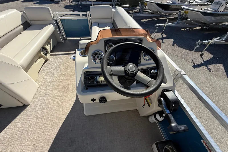 Slide: The Image of 2020 Avalon 2280 Venture Quad Lounger boat interior with steering wheel and seating. - 18