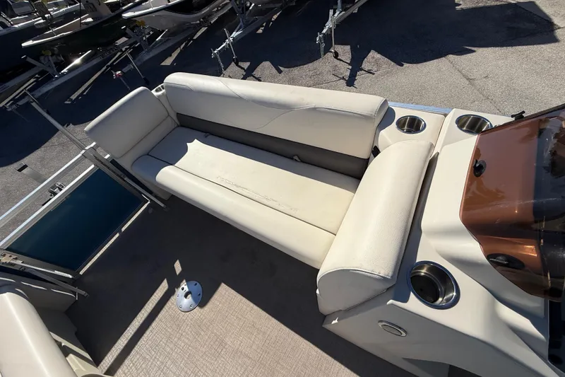 Slide: The Image of 2020 Avalon 2280 Venture Quad Lounger boat interior with beige seating and cup holders. - 19