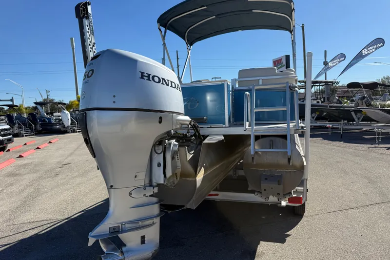 Slide: The Image of 2020 Avalon 2280 Venture Quad Lounger with Honda outboard motor, parked outdoors. - 6