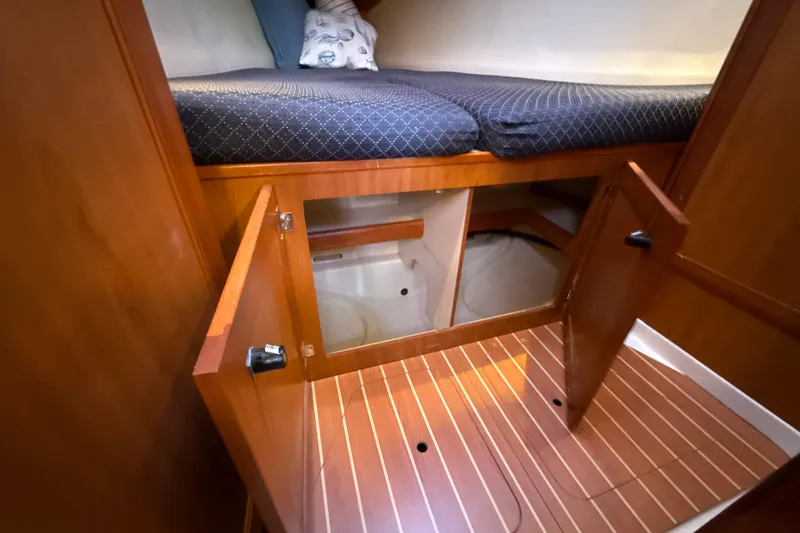 Slide: The Image of 2009 Hunter 38 yacht interior with open storage under bed, wooden flooring. - 13