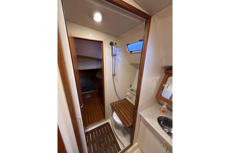 Slide: The Image of 2009 Hunter 38 yacht bathroom with shower, wooden accents, and compact design. - 15