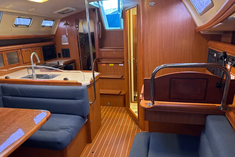 Slide: The Image of Interior of 2009 Hunter 38 sailboat with kitchen, seating, and wooden cabinetry. - 16