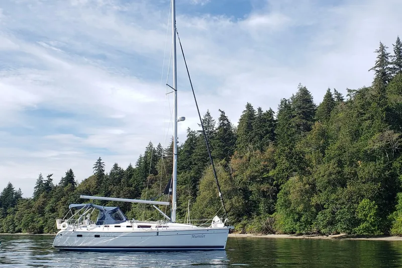 Slide: The Image of 2009 Hunter 38 sailboat on calm water with forested shoreline background. - 2