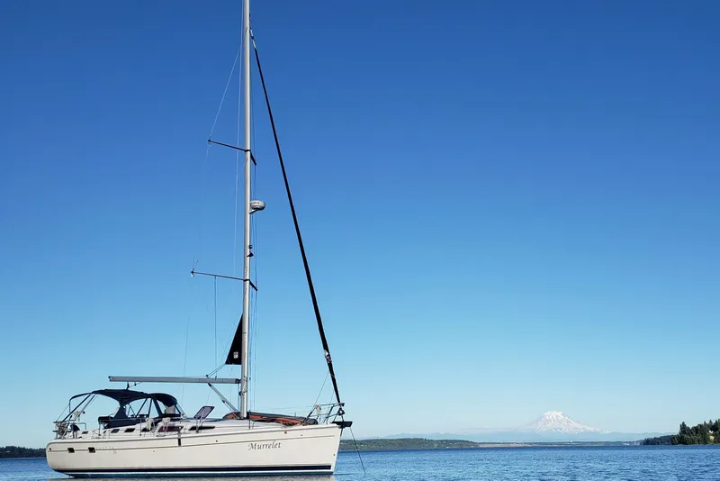 Slide: The Image of 2009 Hunter 38 sailboat on calm water with mountain backdrop. - 27