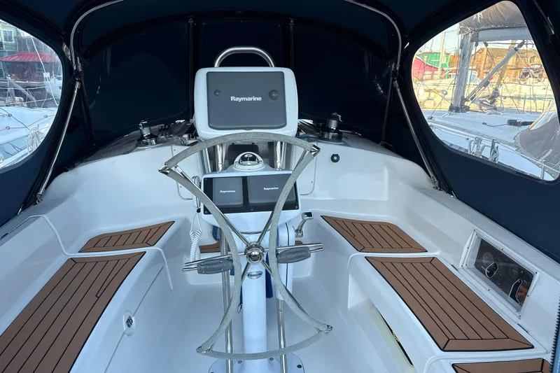 Slide: The Image of 2009 Hunter 38 sailboat cockpit with Raymarine navigation system and wooden seating accents. - 4