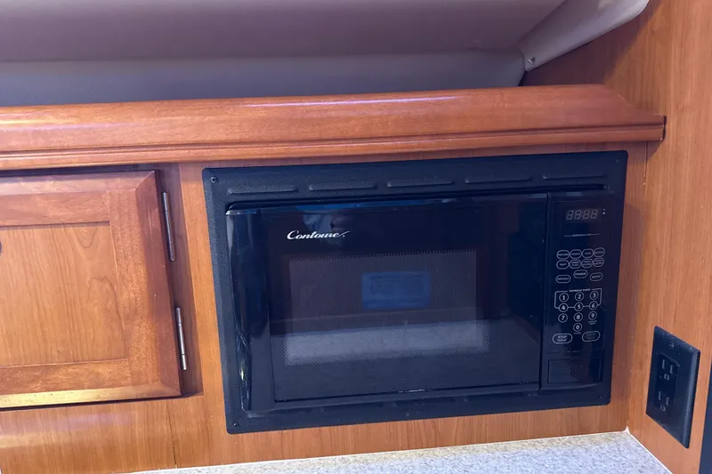 Slide: The Image of Built-in microwave in 2009 Hunter 38 yacht kitchen, featuring wooden cabinetry. - 9