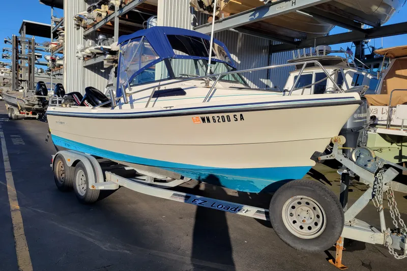The Image of 1998 Arima Sea Ranger 19 boat on trailer, parked in marina storage area. - 0