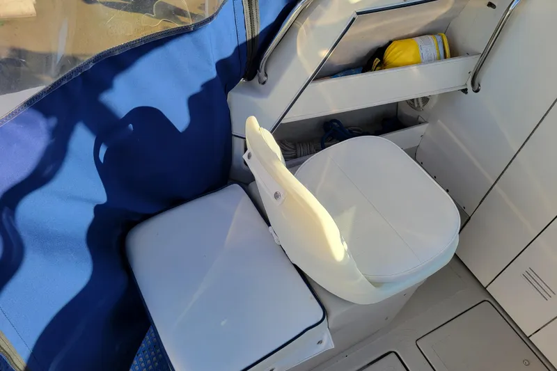 Slide: The Image of 1998 Arima Sea Ranger 19 boat interior with white seating and blue cover. - 10