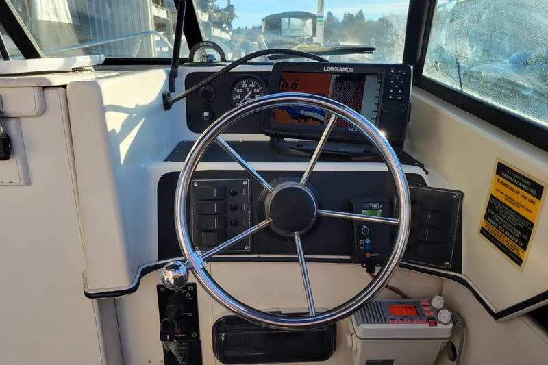 Slide: The Image of 1998 Arima Sea Ranger 19 boat dashboard with steering wheel and navigation equipment. - 12