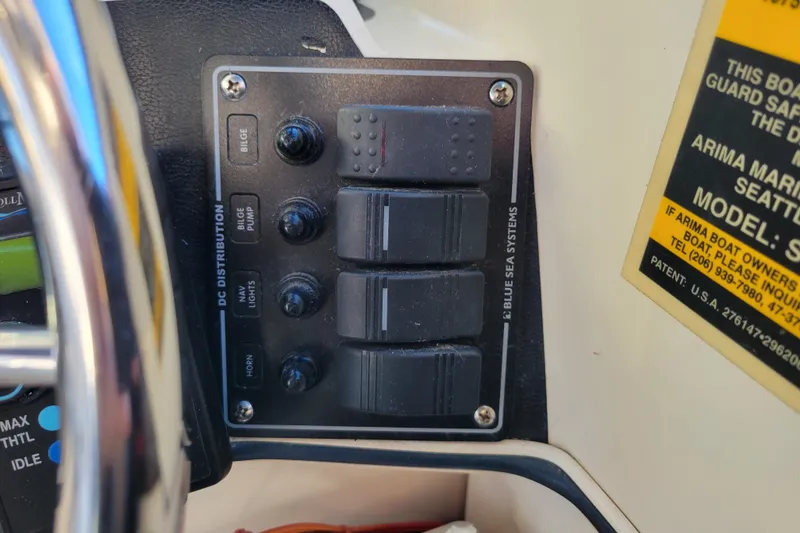 Slide: The Image of Control panel of a 1998 Arima Sea Ranger 19 boat with labeled switches. - 17