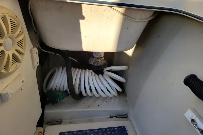 Slide: The Image of Interior view of a 1998 Arima Sea Ranger 19 boat showing coiled hose and speaker. - 25