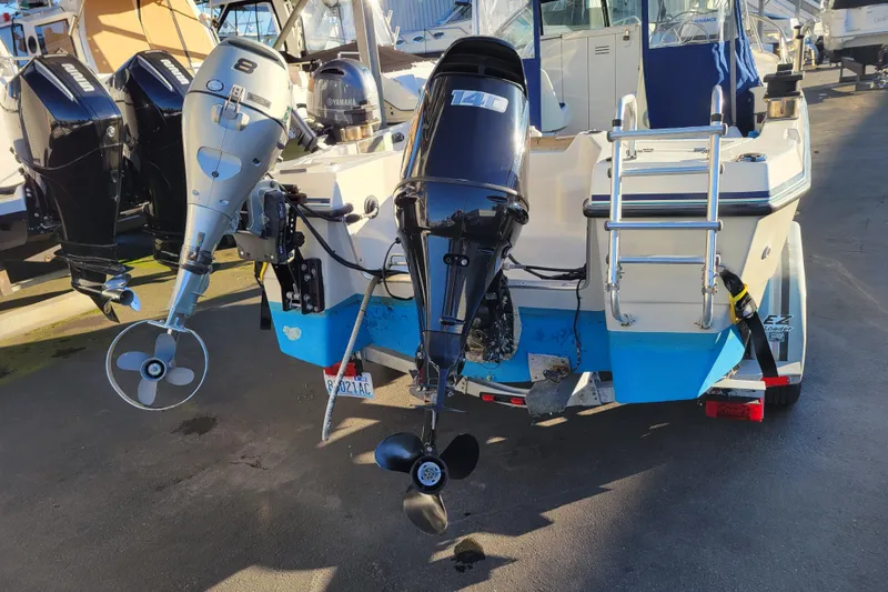 Slide: The Image of 1998 Arima Sea Ranger 19 with dual outboard motors and ladder, docked at marina. - 3