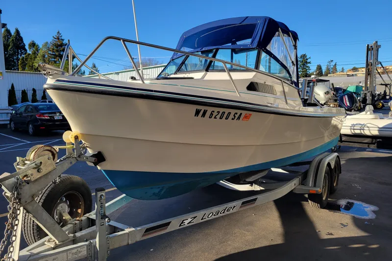 Slide: The Image of 1998 Arima Sea Ranger 19 boat on trailer in parking lot, sunny day. - 4