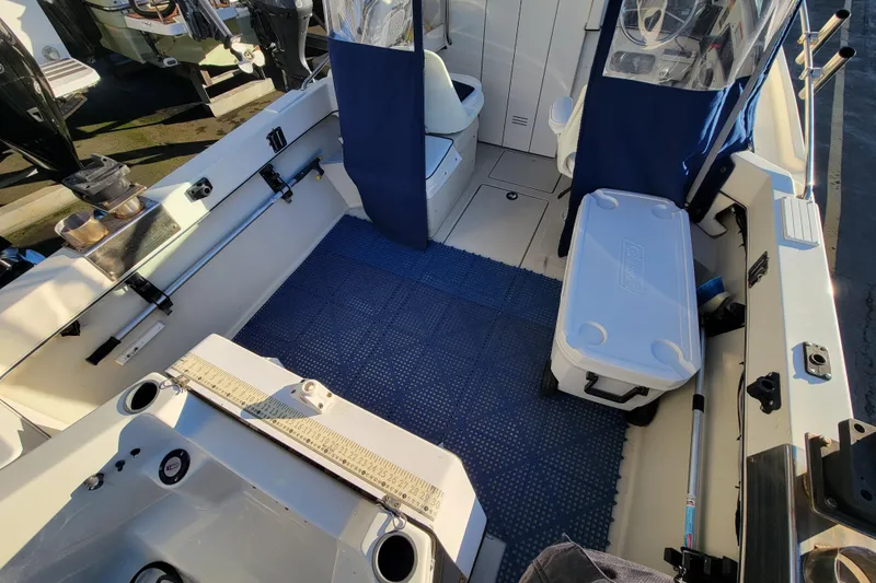 Slide: The Image of 1998 Arima Sea Ranger 19 boat interior with seating, cooler, and fishing equipment. - 7