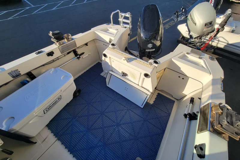 Slide: The Image of 1998 Arima Sea Ranger 19 boat interior with motor, cooler, and fishing equipment. - 8