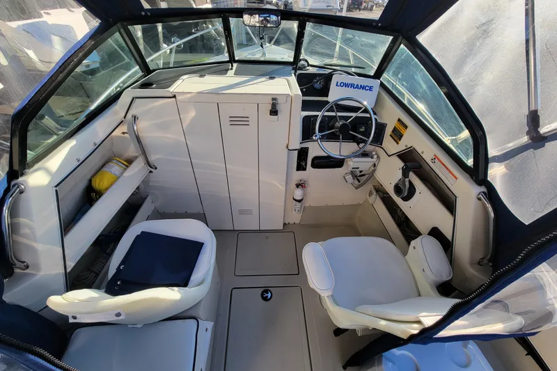 Slide: The Image of Interior of a 1998 Arima Sea Ranger 19 boat with steering wheel and seating. - 9