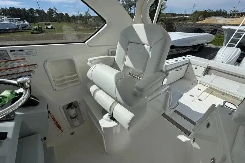 Slide: The Image of 2023 Pursuit OS 355 Offshore boat interior with captain's chair and control panel. - 5