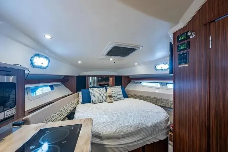 Slide: The Image of 2023 Pursuit OS 355 Offshore cabin interior with bed, wood paneling, and modern amenities. - 6