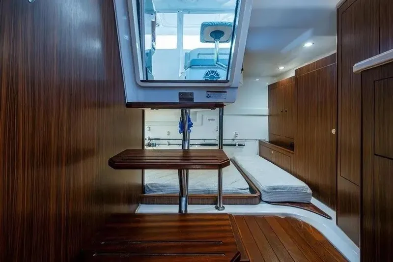 Slide: The Image of 2023 Pursuit OS 355 Offshore cabin interior with wooden finish and compact design. - 9