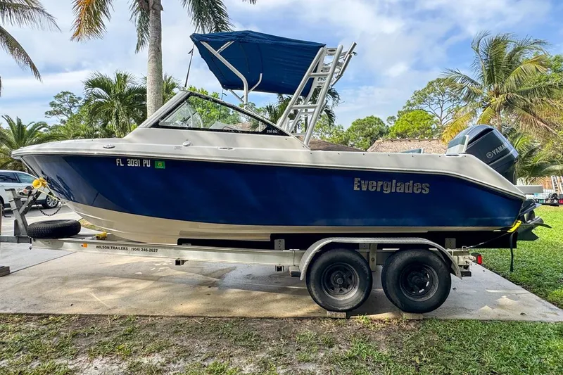 Slide: The Image of 2014 Everglades 230 Dual Console boat on trailer, surrounded by palm trees. - 10