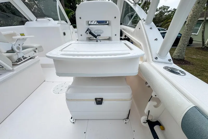 Slide: The Image of 2014 Everglades 230 Dual Console boat interior with seating and storage features. - 100