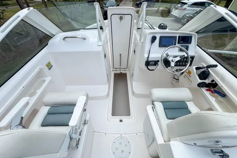 Slide: The Image of 2014 Everglades 230 Dual Console boat interior with steering wheel and seating. - 104