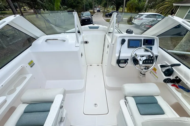 Slide: The Image of 2014 Everglades 230 Dual Console boat interior with steering wheel and seating. - 107