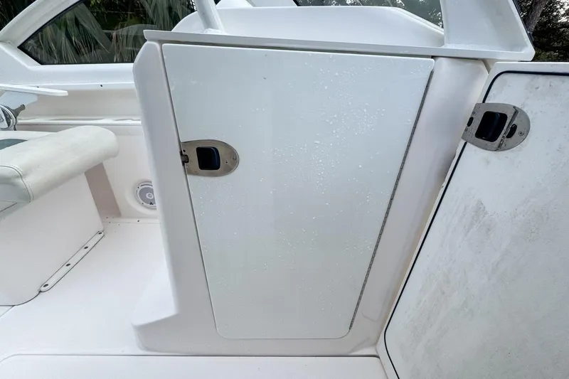 Slide: The Image of 2014 Everglades 230 Dual Console boat interior with white storage compartment. - 113