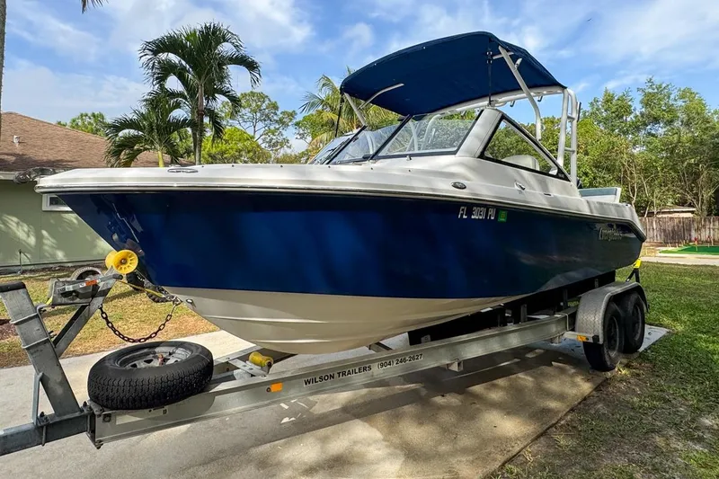 Slide: The Image of 2014 Everglades 230 Dual Console boat on trailer, parked outdoors. - 12